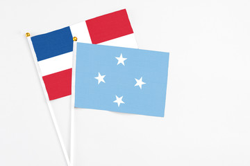 Micronesia and Dominican Republic stick flags on white background. High quality fabric, miniature national flag. Peaceful global concept.White floor for copy space.