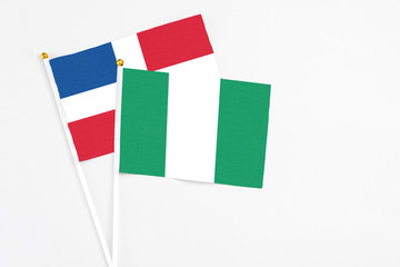 Nigeria and Dominican Republic stick flags on white background. High quality fabric, miniature national flag. Peaceful global concept.White floor for copy space.