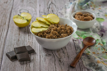 Quinoa and cocoa porridge with Apple on the table with cloth.