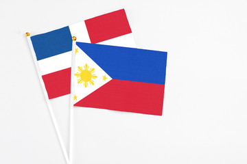 Philippines and Dominican Republic stick flags on white background. High quality fabric, miniature national flag. Peaceful global concept.White floor for copy space.