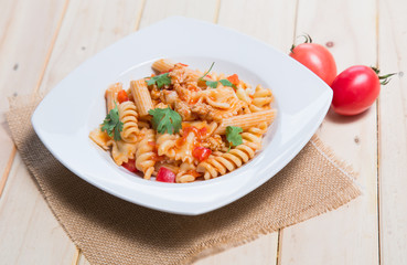 Spaghetti pasta with and tomato sauce on wood background