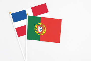 Portugal and Dominican Republic stick flags on white background. High quality fabric, miniature national flag. Peaceful global concept.White floor for copy space.