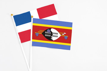 Swaziland and Dominican Republic stick flags on white background. High quality fabric, miniature national flag. Peaceful global concept.White floor for copy space.