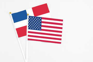 Fototapeta premium United States and Dominican Republic stick flags on white background. High quality fabric, miniature national flag. Peaceful global concept.White floor for copy space.