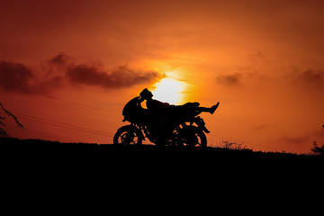 silhouette of biker on background of sunset