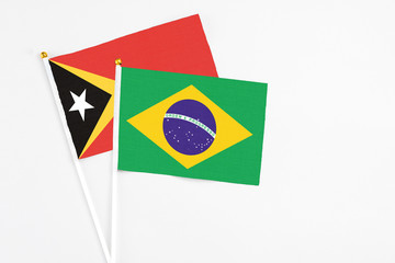 Brazil and East Timor stick flags on white background. High quality fabric, miniature national flag. Peaceful global concept.White floor for copy space.