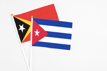 Cuba and East Timor stick flags on white background. High quality fabric, miniature national flag. Peaceful global concept.White floor for copy space.