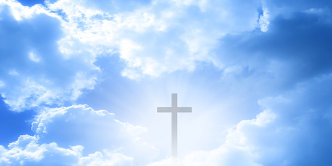 Christian cross appeared bright in the sky with soft fluffy clouds, white, beautiful colors. With the light shining as hope, love and freedom in the sky background