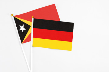 Germany and East Timor stick flags on white background. High quality fabric, miniature national flag. Peaceful global concept.White floor for copy space.
