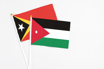 Jordan and East Timor stick flags on white background. High quality fabric, miniature national flag. Peaceful global concept.White floor for copy space.