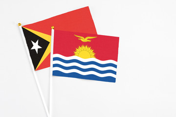 Kiribati and East Timor stick flags on white background. High quality fabric, miniature national flag. Peaceful global concept.White floor for copy space.