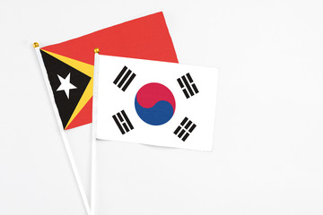 South Korea and East Timor stick flags on white background. High quality fabric, miniature national flag. Peaceful global concept.White floor for copy space.
