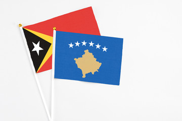 Kosovo and East Timor stick flags on white background. High quality fabric, miniature national flag. Peaceful global concept.White floor for copy space.