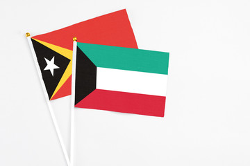 Kuwait and East Timor stick flags on white background. High quality fabric, miniature national flag. Peaceful global concept.White floor for copy space.