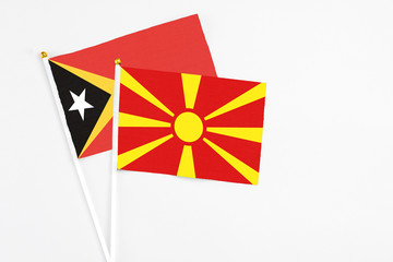 Macedonia and East Timor stick flags on white background. High quality fabric, miniature national flag. Peaceful global concept.White floor for copy space.