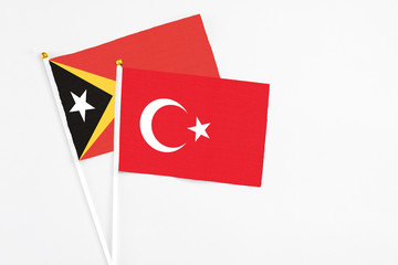 Turkey and East Timor stick flags on white background. High quality fabric, miniature national flag. Peaceful global concept.White floor for copy space.