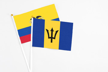 Barbados and Ecuador stick flags on white background. High quality fabric, miniature national flag. Peaceful global concept.White floor for copy space.