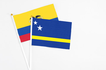 Curacao and Ecuador stick flags on white background. High quality fabric, miniature national flag. Peaceful global concept.White floor for copy space.