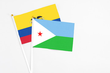 Djibouti and Ecuador stick flags on white background. High quality fabric, miniature national flag. Peaceful global concept.White floor for copy space.