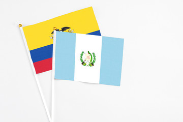 Guatemala and Ecuador stick flags on white background. High quality fabric, miniature national flag. Peaceful global concept.White floor for copy space.