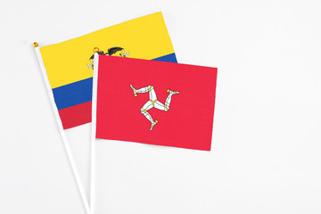 Isle Of Man and Ecuador stick flags on white background. High quality fabric, miniature national flag. Peaceful global concept.White floor for copy space.