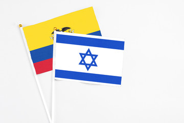 Israel and Ecuador stick flags on white background. High quality fabric, miniature national flag. Peaceful global concept.White floor for copy space.
