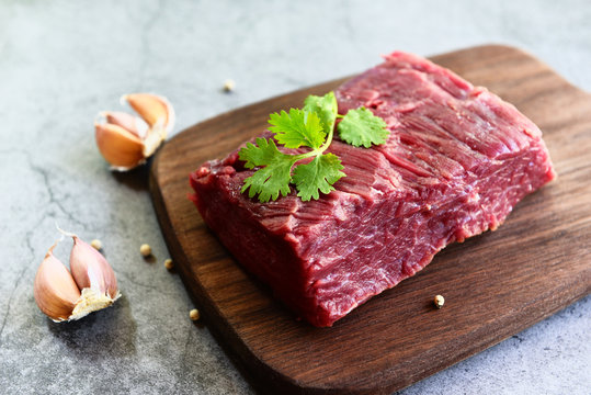 Fresh beef piece for steak or grilled barbecue / Raw meat beef steak with spices garlic on wooden cutting board and black background