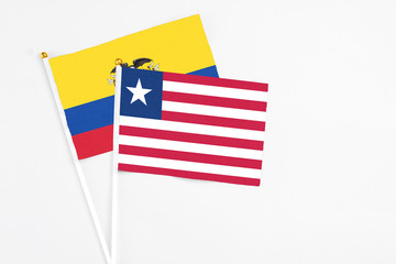 Liberia and Ecuador stick flags on white background. High quality fabric, miniature national flag. Peaceful global concept.White floor for copy space.