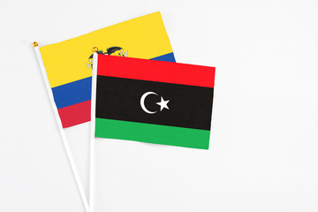 Libya and Ecuador stick flags on white background. High quality fabric, miniature national flag. Peaceful global concept.White floor for copy space.