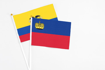 Liechtenstein and Ecuador stick flags on white background. High quality fabric, miniature national flag. Peaceful global concept.White floor for copy space.