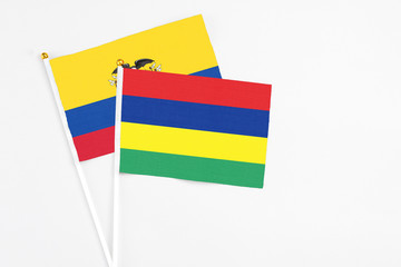 Mauritius and Ecuador stick flags on white background. High quality fabric, miniature national flag. Peaceful global concept.White floor for copy space.