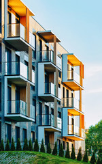 Modern residential apartment with flat building exterior and outdoor facilities. New luxury house and home complex and green yard. City Real estate property and condo architecture. Empty background