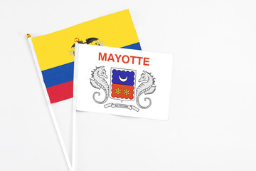 Mayotte and Ecuador stick flags on white background. High quality fabric, miniature national flag. Peaceful global concept.White floor for copy space.