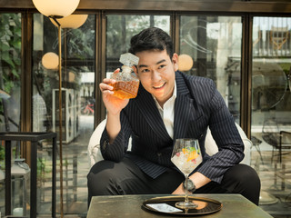 Handsome Asian businessman drinking fusion tea in cafe, lifestyle