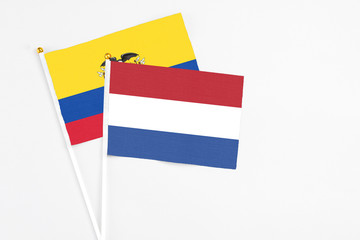 Netherlands and Ecuador stick flags on white background. High quality fabric, miniature national flag. Peaceful global concept.White floor for copy space.