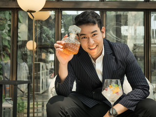 Handsome Asian businessman drinking fusion tea in cafe, lifestyle
