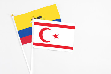 Northern Cyprus and Ecuador stick flags on white background. High quality fabric, miniature national flag. Peaceful global concept.White floor for copy space.