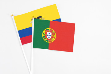 Portugal and Ecuador stick flags on white background. High quality fabric, miniature national flag. Peaceful global concept.White floor for copy space.