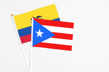 Puerto Rico and Ecuador stick flags on white background. High quality fabric, miniature national flag. Peaceful global concept.White floor for copy space.