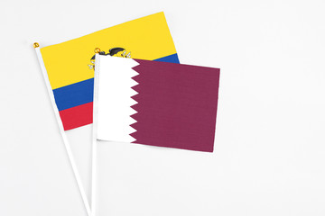 Qatar and Ecuador stick flags on white background. High quality fabric, miniature national flag. Peaceful global concept.White floor for copy space.