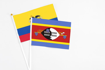 Swaziland and Ecuador stick flags on white background. High quality fabric, miniature national flag. Peaceful global concept.White floor for copy space.