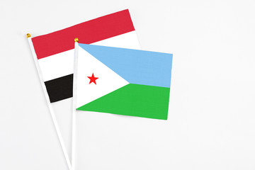 Djibouti and Egypt stick flags on white background. High quality fabric, miniature national flag. Peaceful global concept.White floor for copy space.