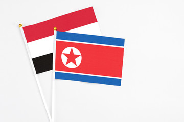 North Korea and Egypt stick flags on white background. High quality fabric, miniature national flag. Peaceful global concept.White floor for copy space.