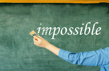 hand erasing prefix of impossible on chalkboard