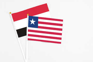 Liberia and Egypt stick flags on white background. High quality fabric, miniature national flag. Peaceful global concept.White floor for copy space.