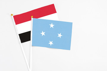Micronesia and Egypt stick flags on white background. High quality fabric, miniature national flag. Peaceful global concept.White floor for copy space.