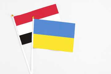 Ukraine and Egypt stick flags on white background. High quality fabric, miniature national flag. Peaceful global concept.White floor for copy space.