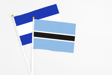 Botswana and El Salvador stick flags on white background. High quality fabric, miniature national flag. Peaceful global concept.White floor for copy space.