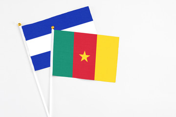 Cameroon and El Salvador stick flags on white background. High quality fabric, miniature national flag. Peaceful global concept.White floor for copy space.