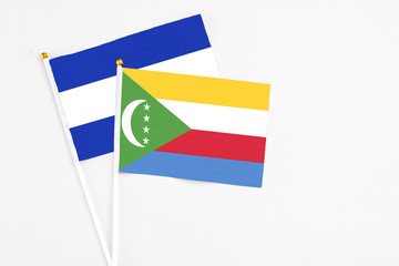 Comoros and El Salvador stick flags on white background. High quality fabric, miniature national flag. Peaceful global concept.White floor for copy space.